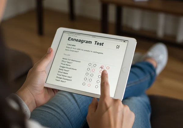 Persona haciendo un test del Eneagrama en una tableta moderna.